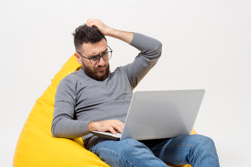 guy-frustrated-while-sitting-yellow-pouf-chair (1)